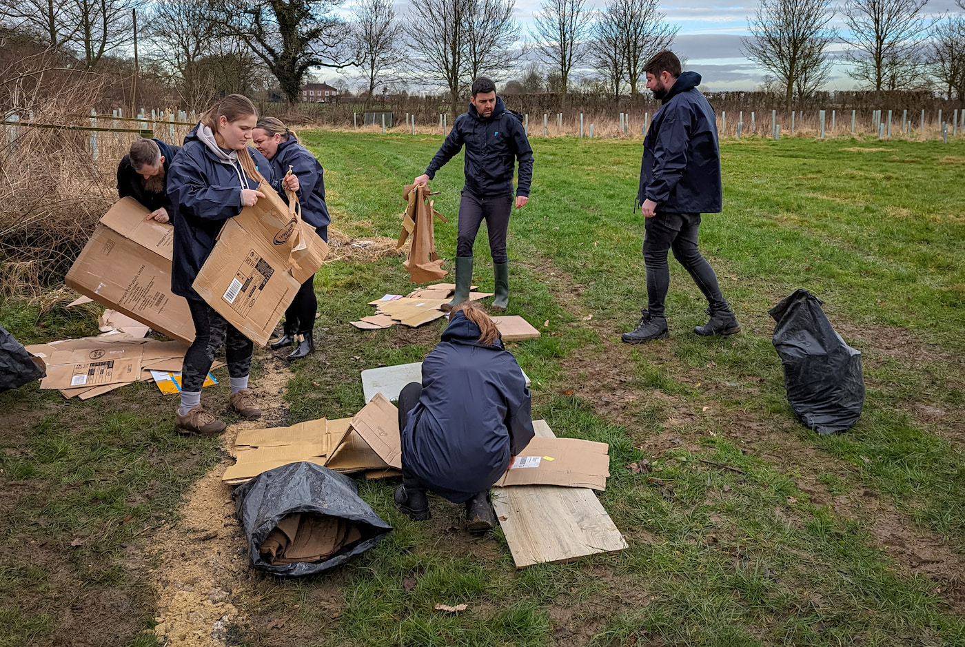 The Far'n'Beyond Team preparing cardboard sheets for planting trees from old biodegradable boxes.