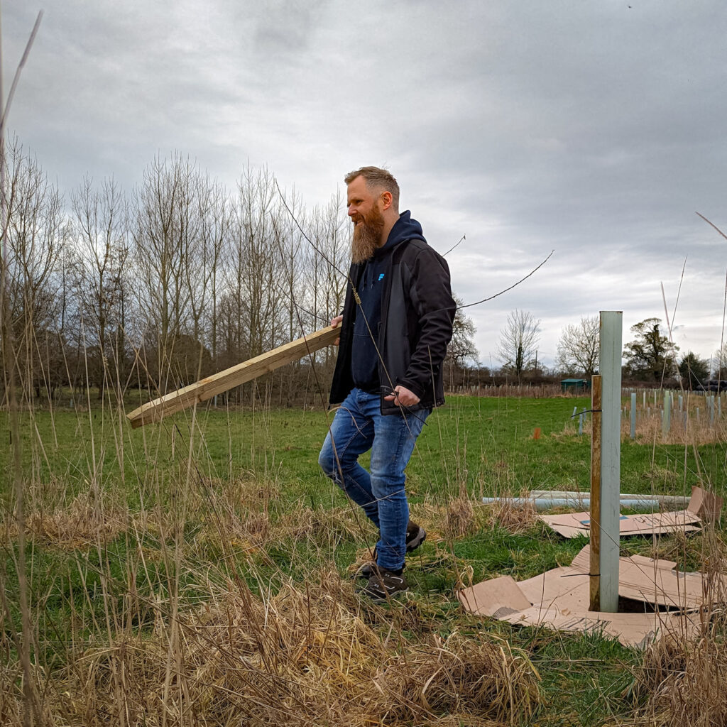 Nathan carrying a stake, used for maintaining the trees on the Make It Wild site.