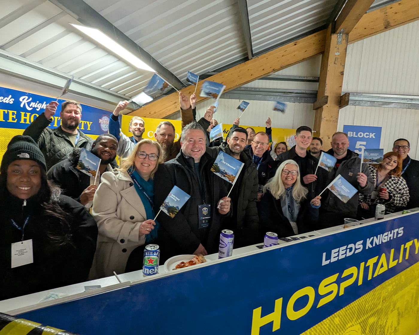 Far'n'Beyond Team at Leeds Knights Ice Hockey Match waving flags.